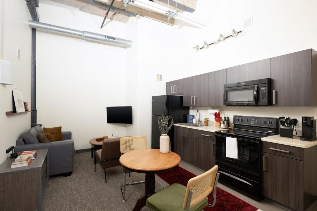 a kitchen and living room with a table and a couch at Cream City 2BR Apt - Just 3 Blocks to Fiserv with Gym and Parking in Milwaukee