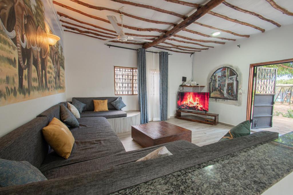 un salon avec un canapé et une cheminée dans l'établissement Cozy house 140 sqm with pool, à Diani Beach