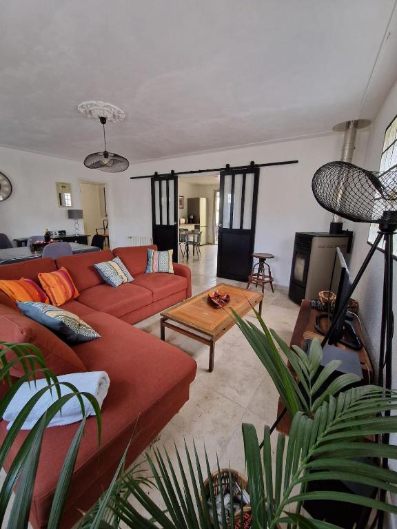 un salon avec un canapé rouge et une table dans l'établissement Parenthèse Bergeracoise, à Bergerac