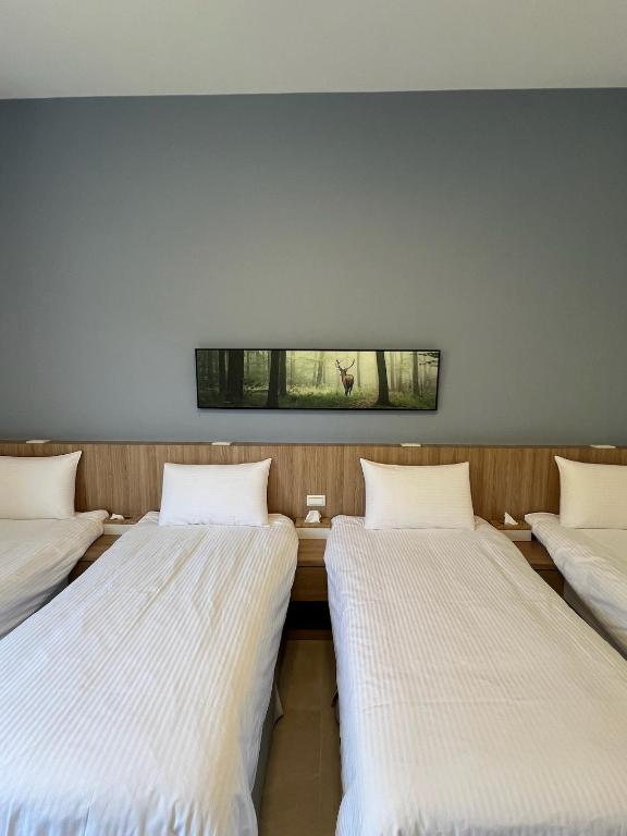 three beds in a room with a window at Dawn Valley in Green Island