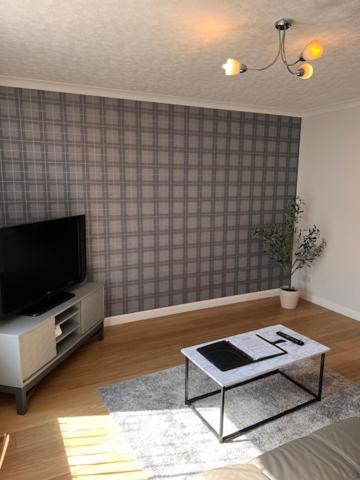 a living room with a tv and a coffee table at Kelpies Serviced Apartments- McLaughlan in Falkirk