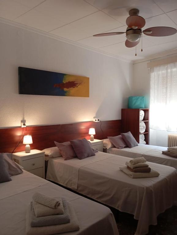 a bedroom with two beds and a ceiling fan at Manzaneque Rural House in Caudete de las Fuentes