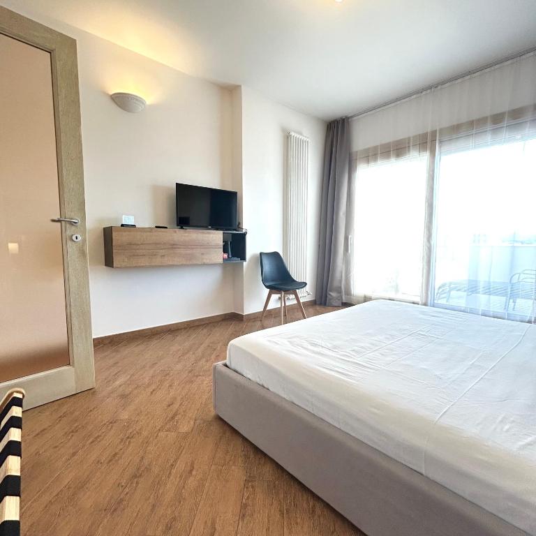 una camera da letto con un letto, una sedia e una finestra di Tra Mare & Monti - Bed & Breakfast a Olbia