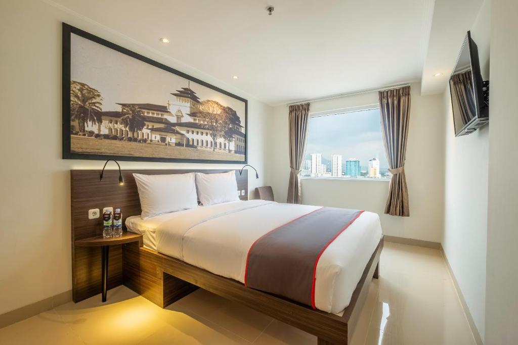 une chambre avec un grand lit et une fenêtre dans l'établissement Townhouse Oak Pasar Baru Heritage, à Bandung