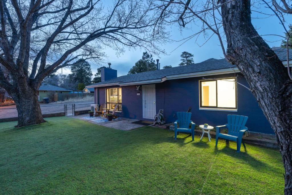 a blue house with two chairs and a table in the yard at Scenic Mountain Getaway by the Park in Flagstaff