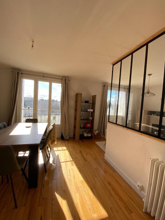 une salle à manger avec une table et une grande fenêtre dans l'établissement Appartement centre-ville Quimper, à Quimper