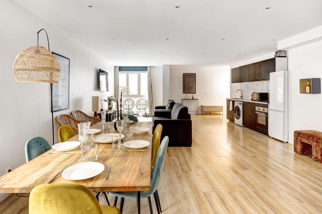 une salle à manger et un salon avec une table et des chaises dans l'établissement Sejour elegant aux Buttes Chaumont pour 12 pers, à Paris