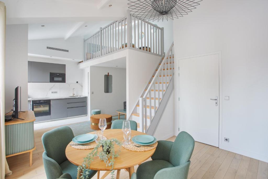 une salle à manger avec une table et des chaises et un escalier dans l'établissement Appartement lumineux dans Paris - Climatisé, à Paris