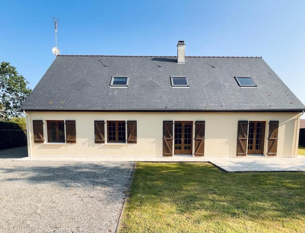 une grande maison blanche avec un toit gris dans l'établissement Villa Rose, à Graignes