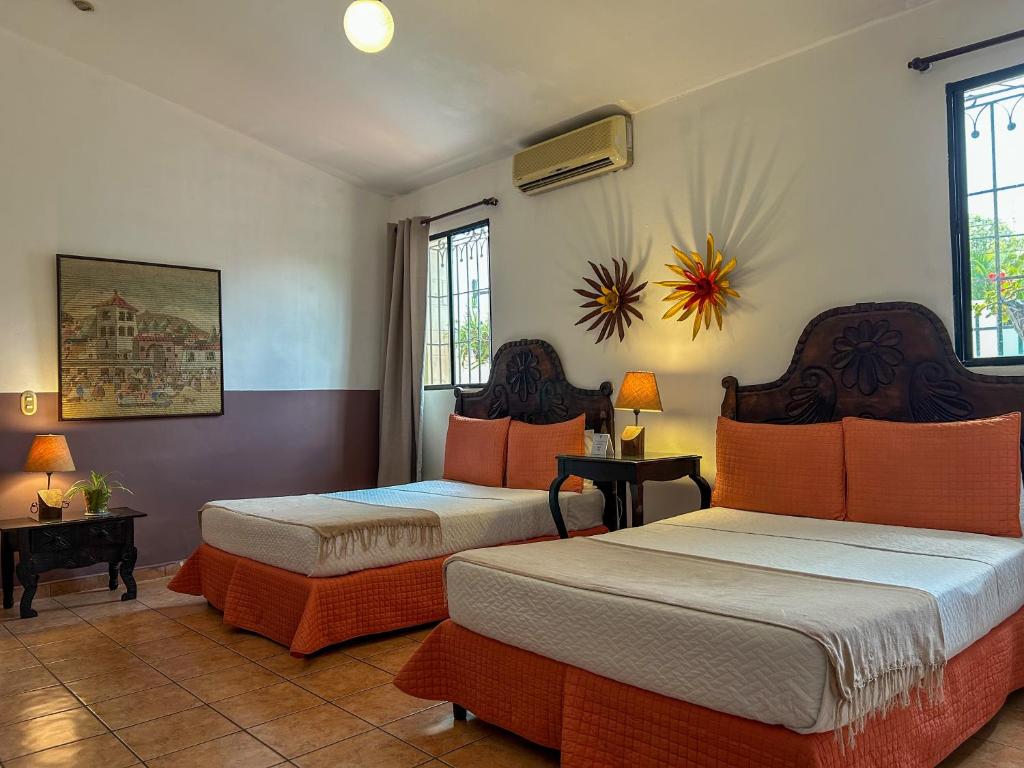 ein Hotelzimmer mit 2 Betten und 2 Fenstern in der Unterkunft Hotel La Posada del Angel in San Salvador