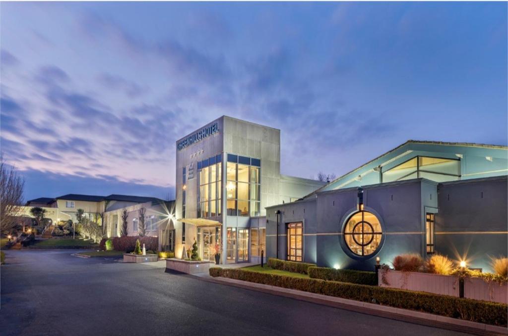 Un edificio con un reloj en el costado. en Greenhills Hotel Limerick, en Limerick