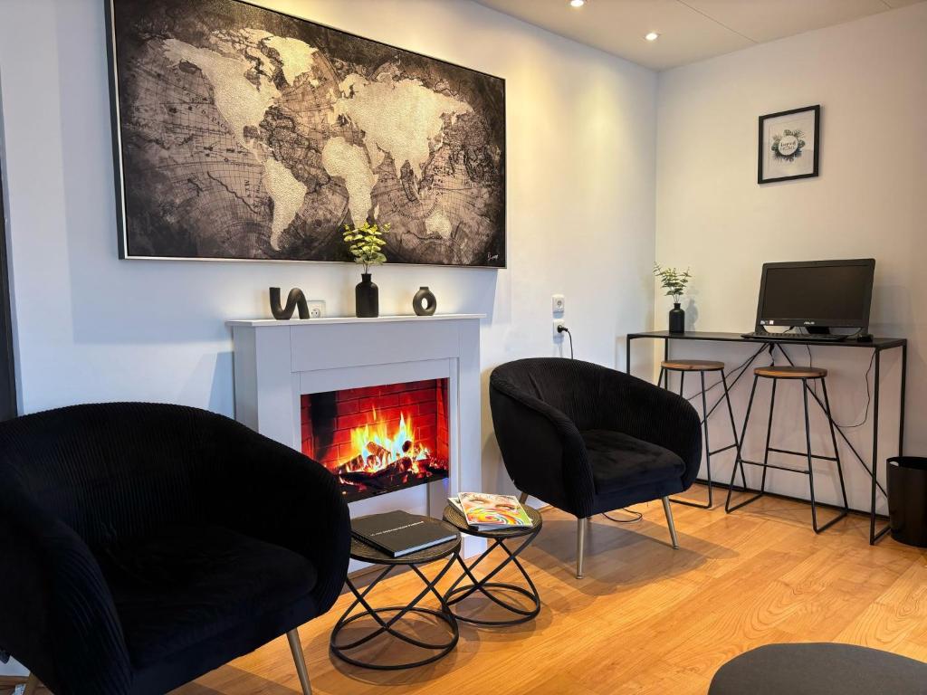 un salon avec deux chaises et une cheminée dans l'établissement Hôtel Le Valois, Cognac Centre, à Cognac