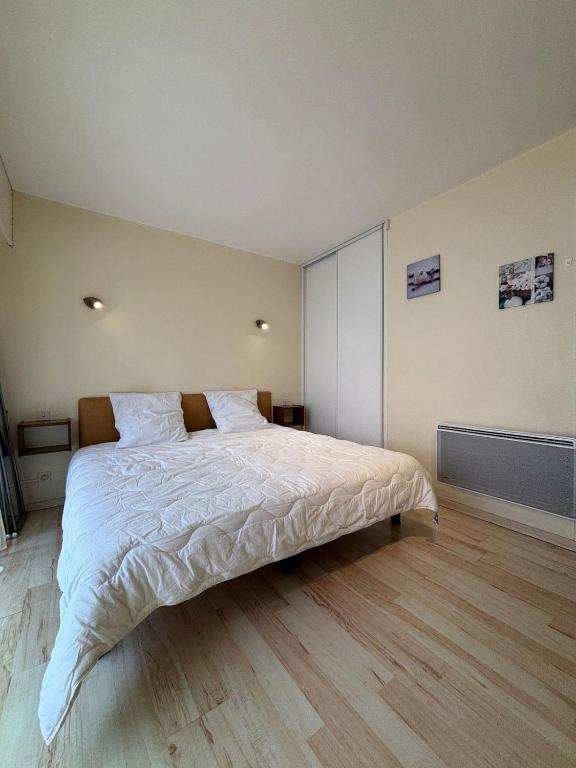 une chambre avec un grand lit avec des draps blancs dans l'établissement StudiosMichel apt 14 terrasse thermes 400m à pied, à Cazaubon
