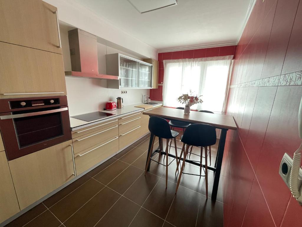 eine Küche mit einem Tisch und zwei Barhockern in der Unterkunft Amancay in Cedeira