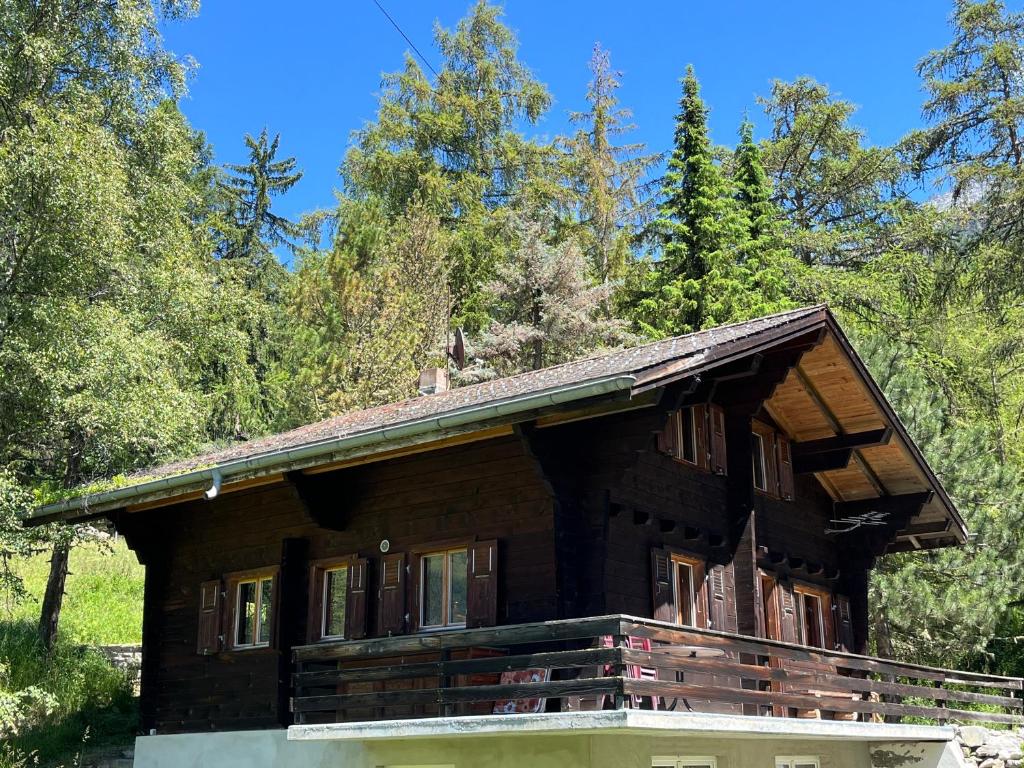 a log cabin in the woods with trees at Chalet Karin in Sankt Niklaus