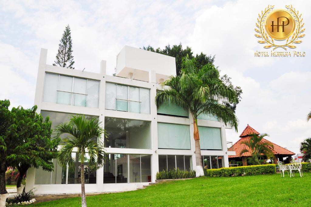 un edificio con una palmera delante de él en Hotel Herrera Polo, en San Pedro