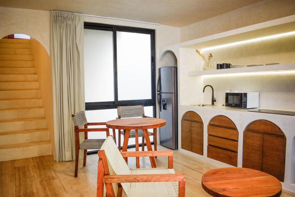 a living room with a table and a kitchen at Studio in La Veleta with private rooftop in Tulum