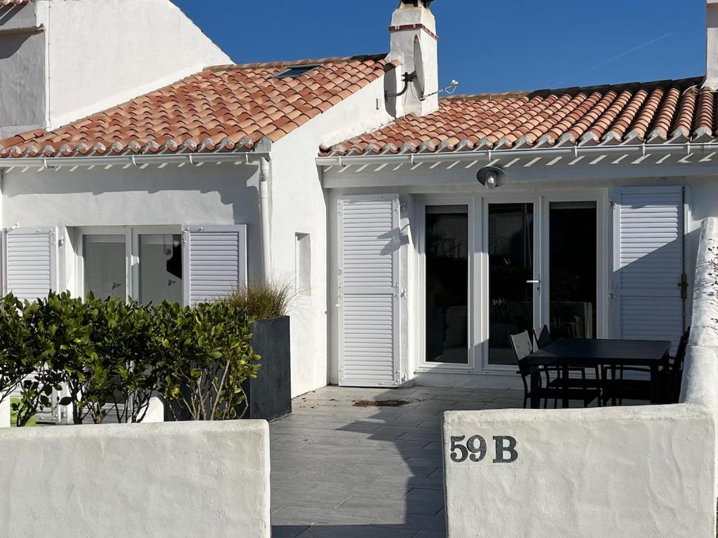 une maison blanche avec une table devant elle dans l'établissement Maison dans un village boiséprès de la plage, à La Celle-sous-Gouzon
