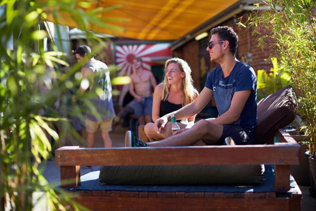 a man and a woman sitting on a bench at Old Fire Station Backpackers in Fremantle