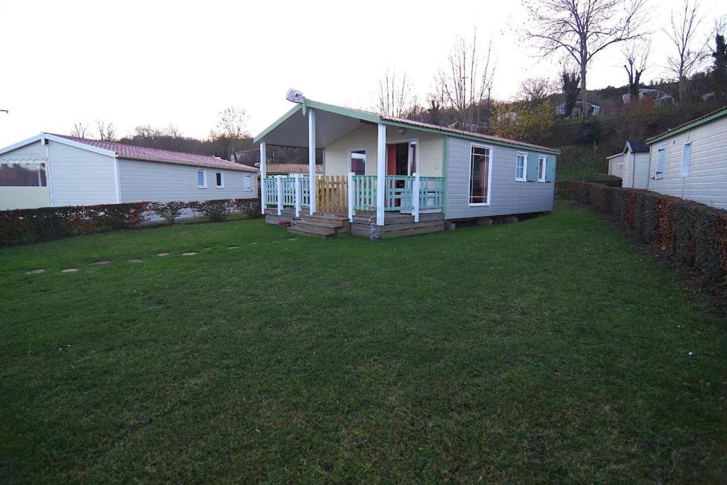 a small house with a porch and a yard at Mobil-home a la campagne proche de la mer in Criel-sur-Mer