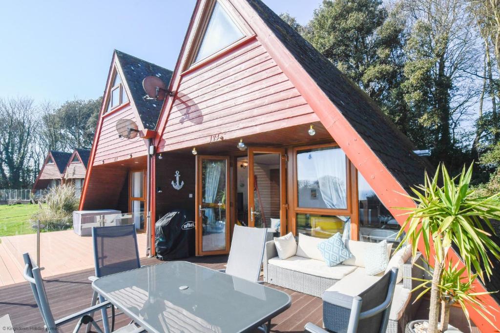 a small house with a table and chairs on a deck at Chalet 124 in Deal