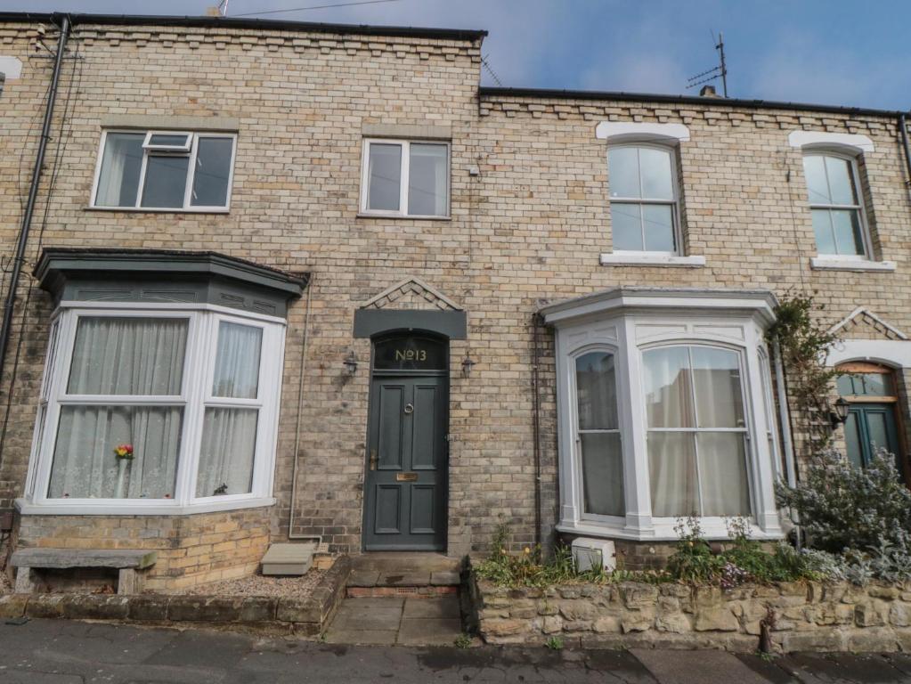 a brick house with a black door and white windows at Top-Notch Flat in Saltburn-by-the-Sea