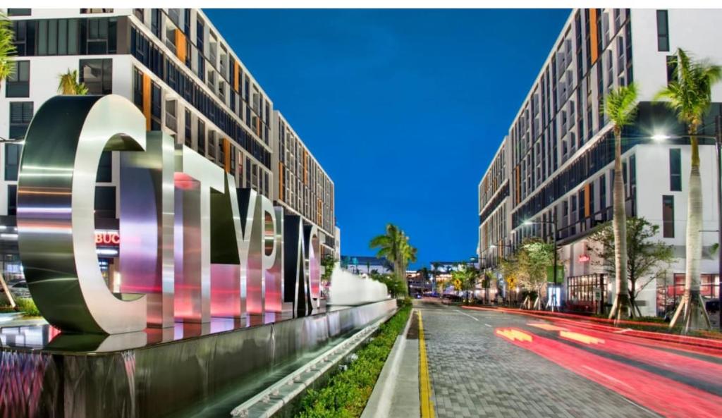 a city street with buildings and palm trees at Down Town Doral 1b in Miami