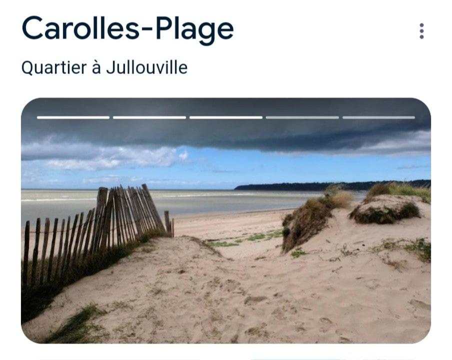 une photo d'une plage avec une clôture en bois dans l'établissement L'escapade, à Carolles
