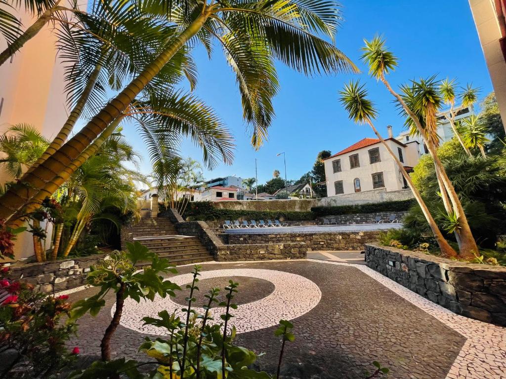 Un patio con palmeras y un edificio. en Apto Barreiro by Susy's Holidays, en Funchal