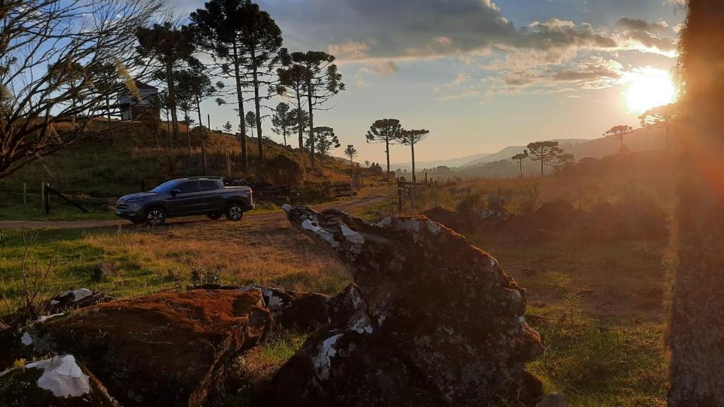 a truck driving down a road in a field at Pousada Luar dos Campos in Bom Jardim da Serra