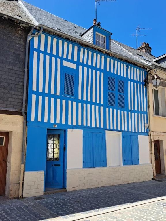 un bâtiment bleu et blanc avec une porte bleue dans l'établissement Maison Normande Honfleur, à Honfleur