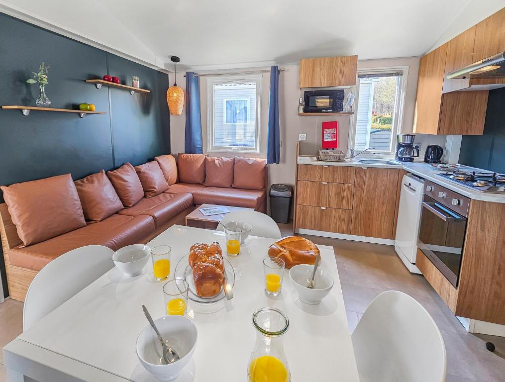 a kitchen and living room with a table with food on it at le Nomatitoz in Litteau