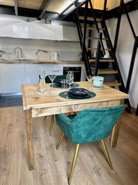 une table en bois avec une assiette et des verres dans l'établissement Douce Parenthèse, à Roanne