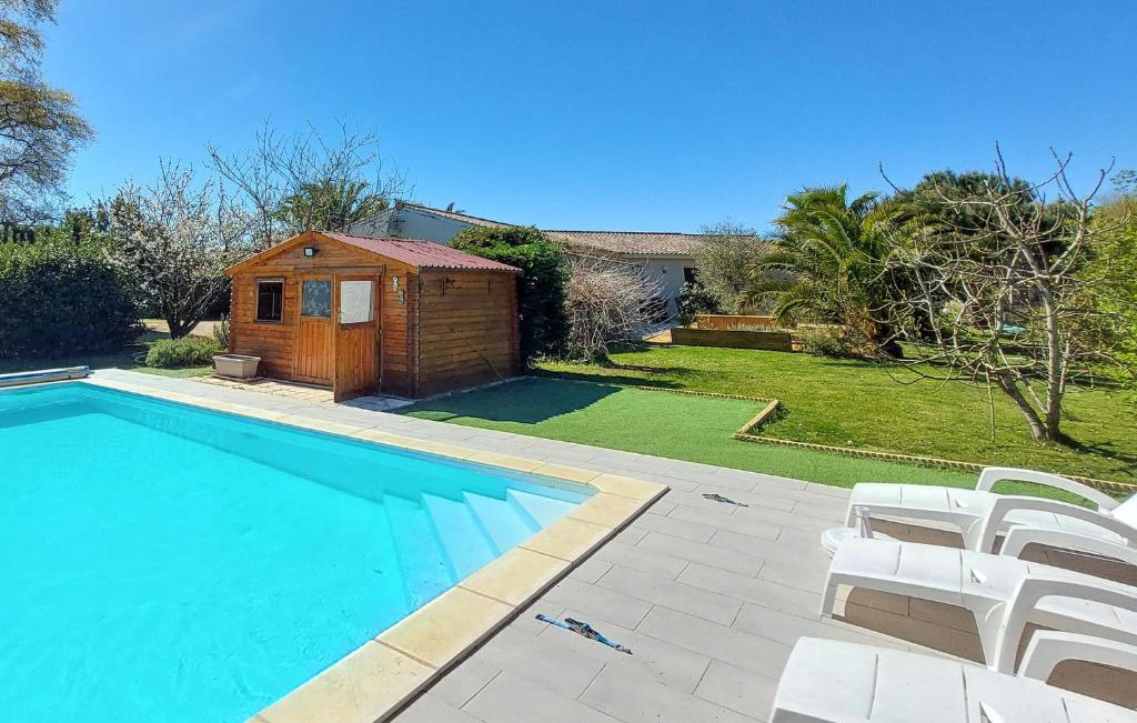 une piscine avec des chaises blanches et une maison dans l'établissement Lovely Home In Vensac, à Vensac