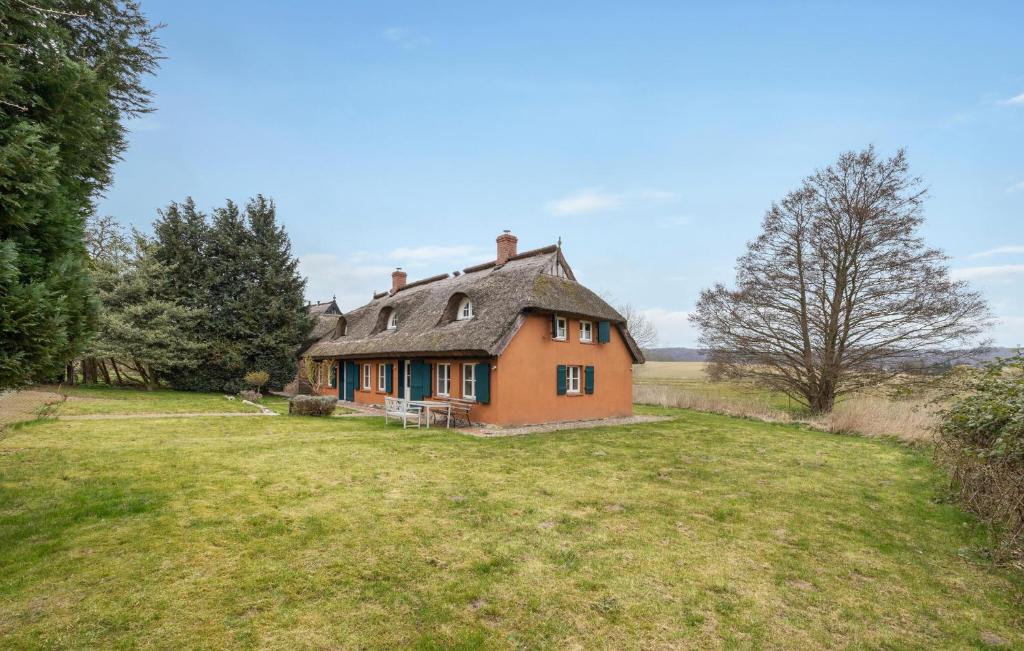 een oranje huis in een veld met een tuin bij Ferienwohnung Diana in Lancken-Granitz