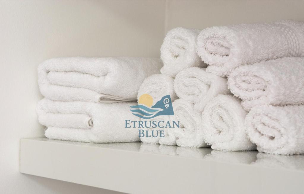 a pile of towels sitting on a shelf at Etruscan Blue House in Piombino