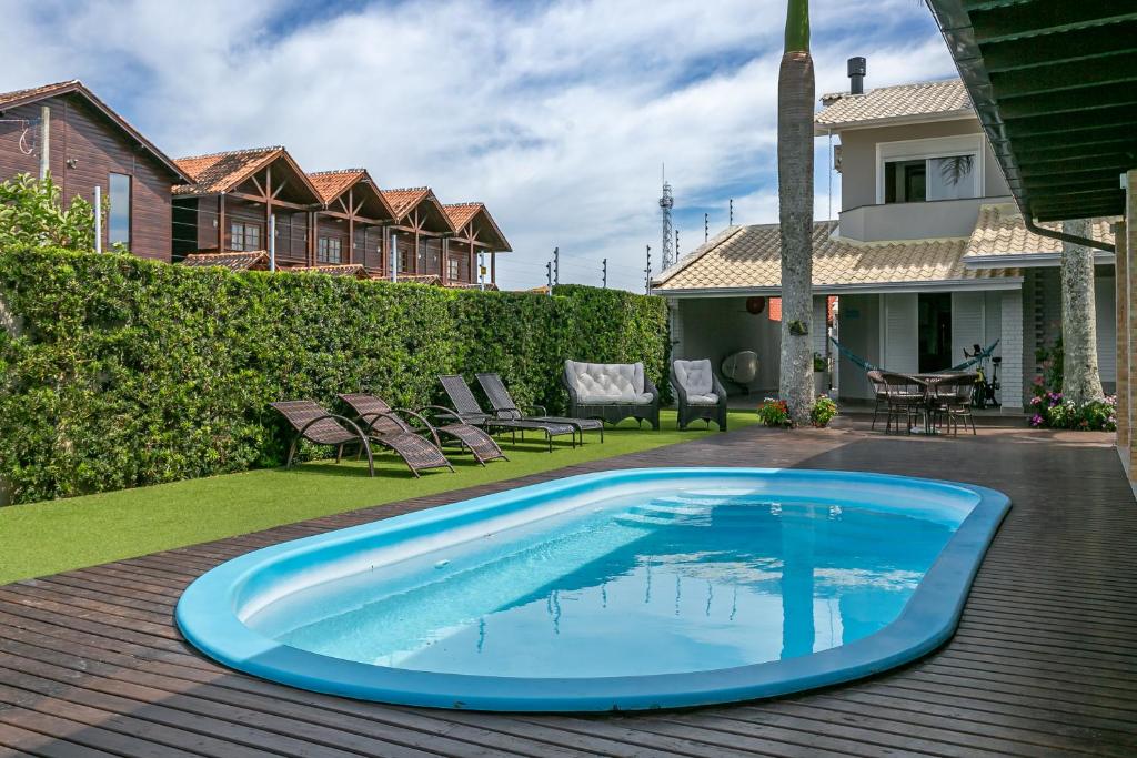 a swimming pool on a deck next to a house at RJ Residencial Beira Mar in Palhoça