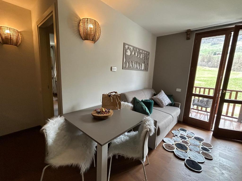 a living room with a couch and a table at Maison Du Coeur Champoluc - Spa, Gym e aree relax in Champoluc