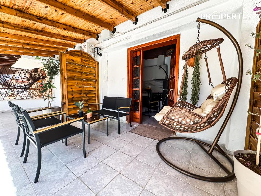 a porch with chairs and a swing at Cypress Seaside Apartment #PROPERTLY in Nea Kallikrateia