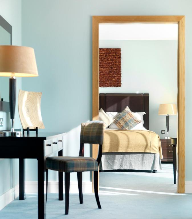 a bedroom with a bed and a desk and a bed with a mirror at Cork International Hotel in Cork