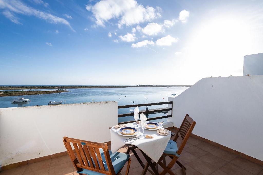 a table and chairs on a balcony with a view of the ocean at NEW !! Studio Ria Formosa - Cabanas de Tavira in Cabanas de Tavira