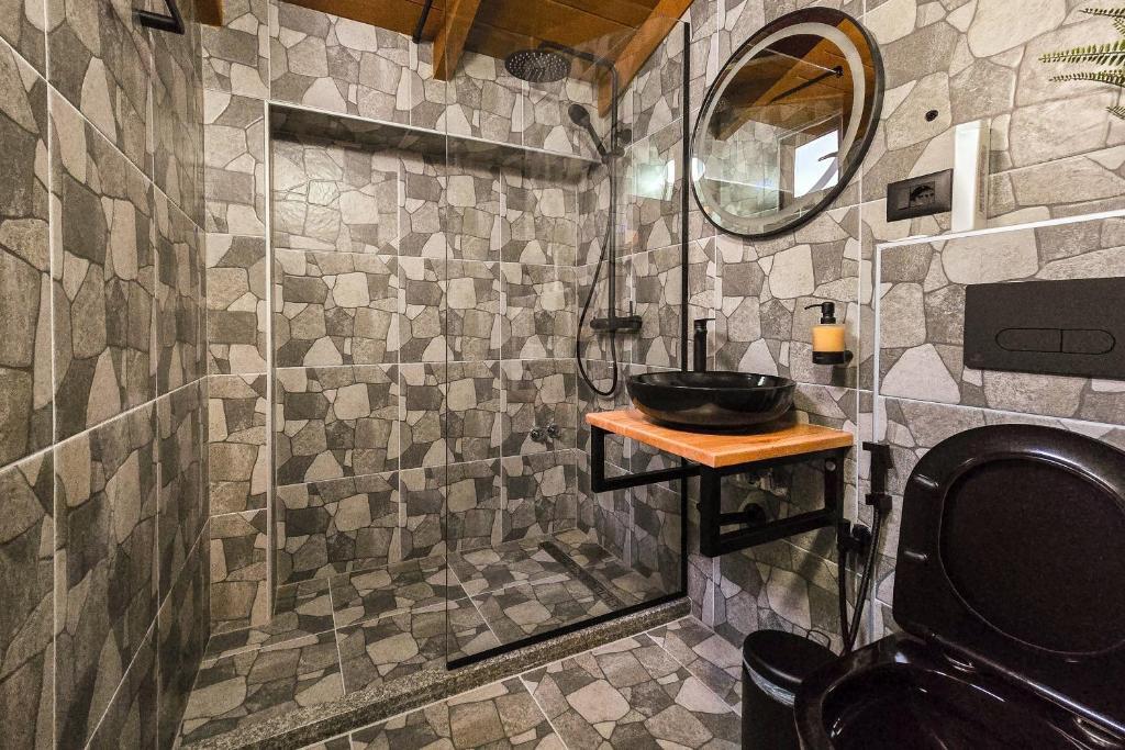 y baño con lavabo y ducha acristalada. en Silver Hill Guesthouse, en Gjirokastra