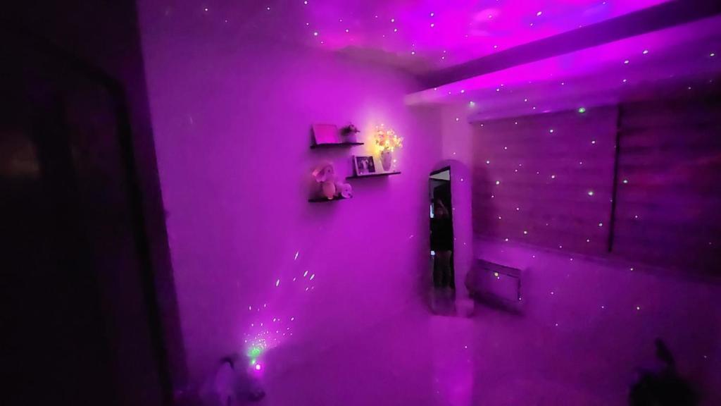 ein lila Zimmer mit einem Spiegel und lila Lichtern in der Unterkunft Anna's cozy house in Angeles