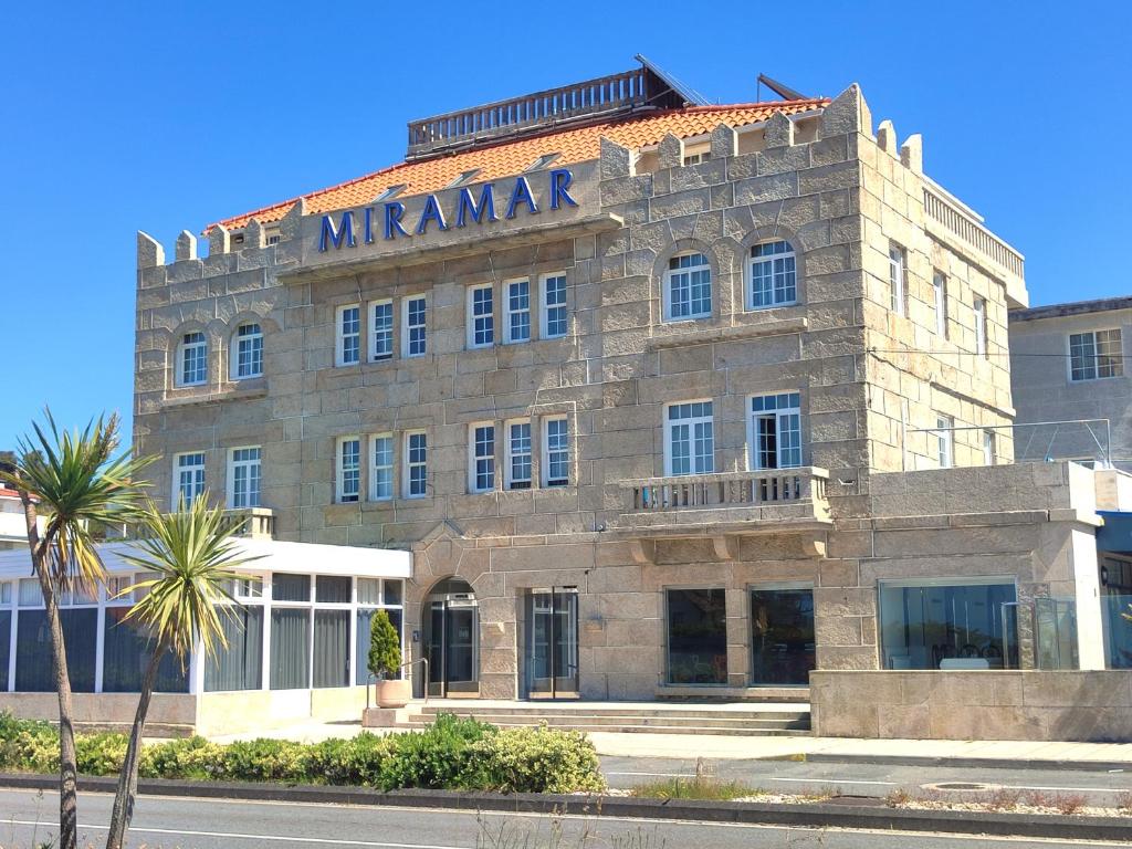 a large stone building with a manuscript sign on it at Hotel Miramar Playa America Nigran in Nigrán
