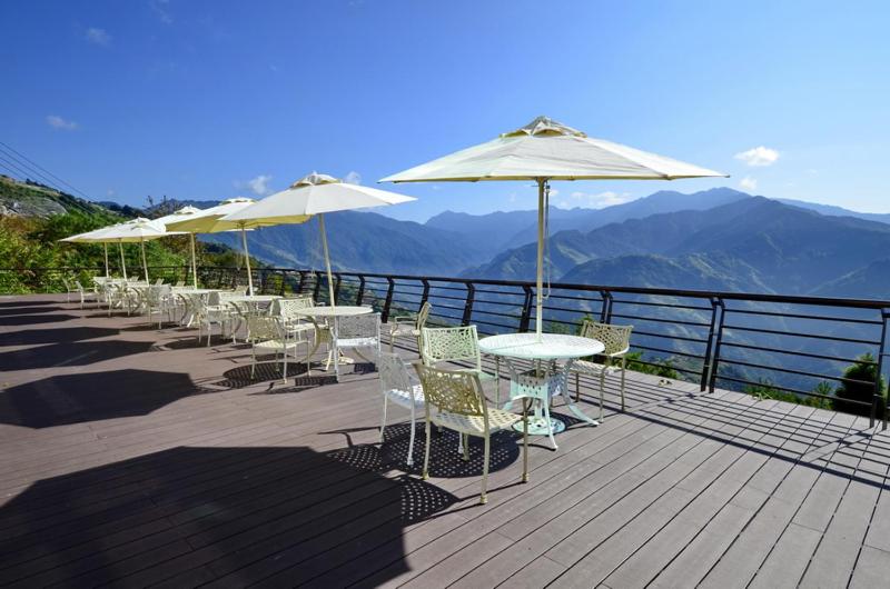 a row of tables and chairs with umbrellas on a deck at Jun Yue Hanging Garden Resort in Ren&#39;ai