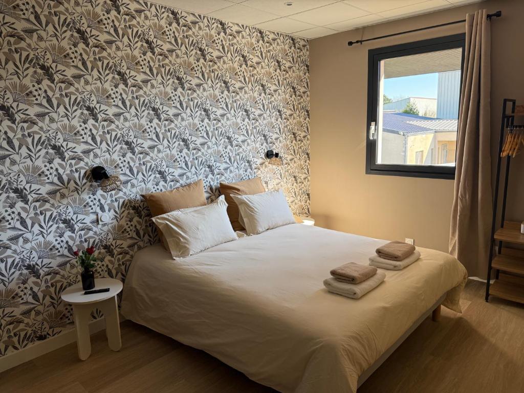 a bedroom with a bed with towels on it at Suite du Spa 1 - Parking Privé Gratuit in Reims
