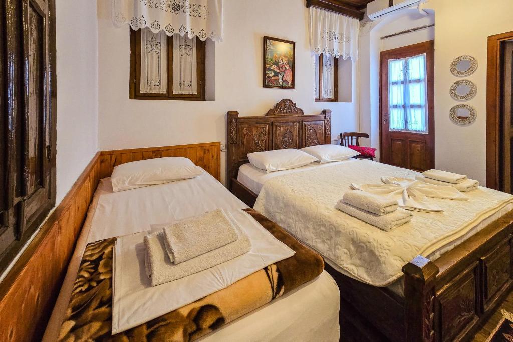 1 dormitorio con 2 camas y toallas. en Silver Hill Guesthouse, en Gjirokastra