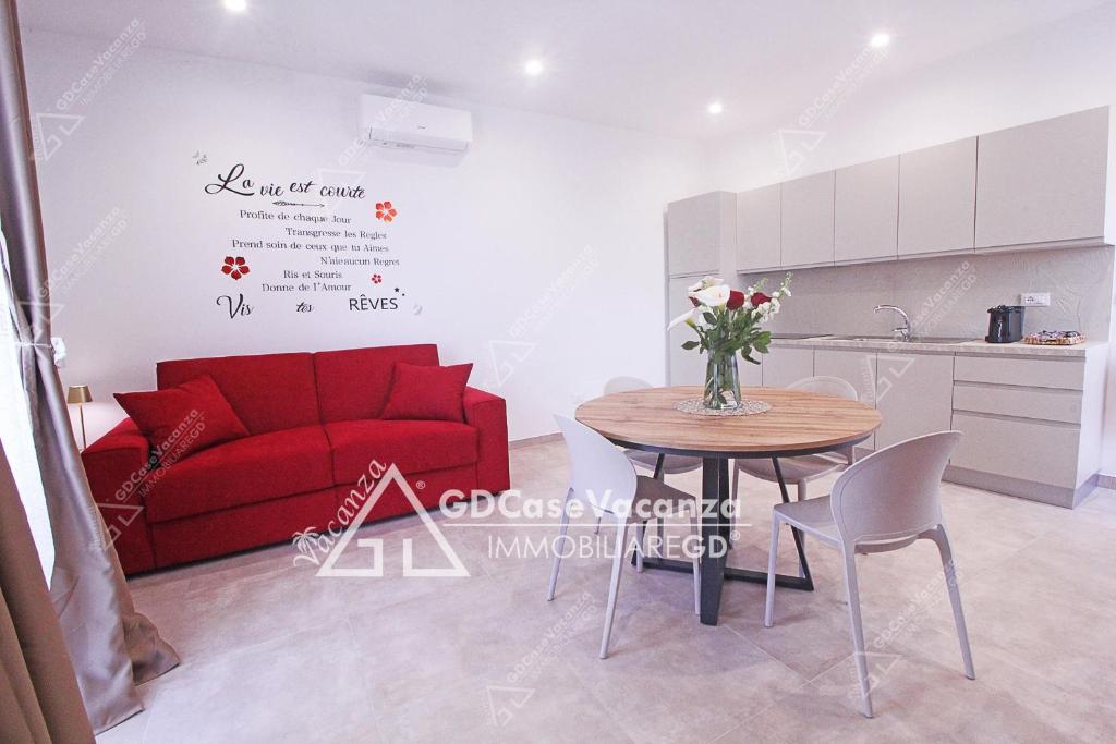ein Wohnzimmer mit einem roten Sofa und einem Tisch in der Unterkunft GD Case Vacanza - Suite del Conte - Salento Luxury Private Suite Idromassaggio in Specchia