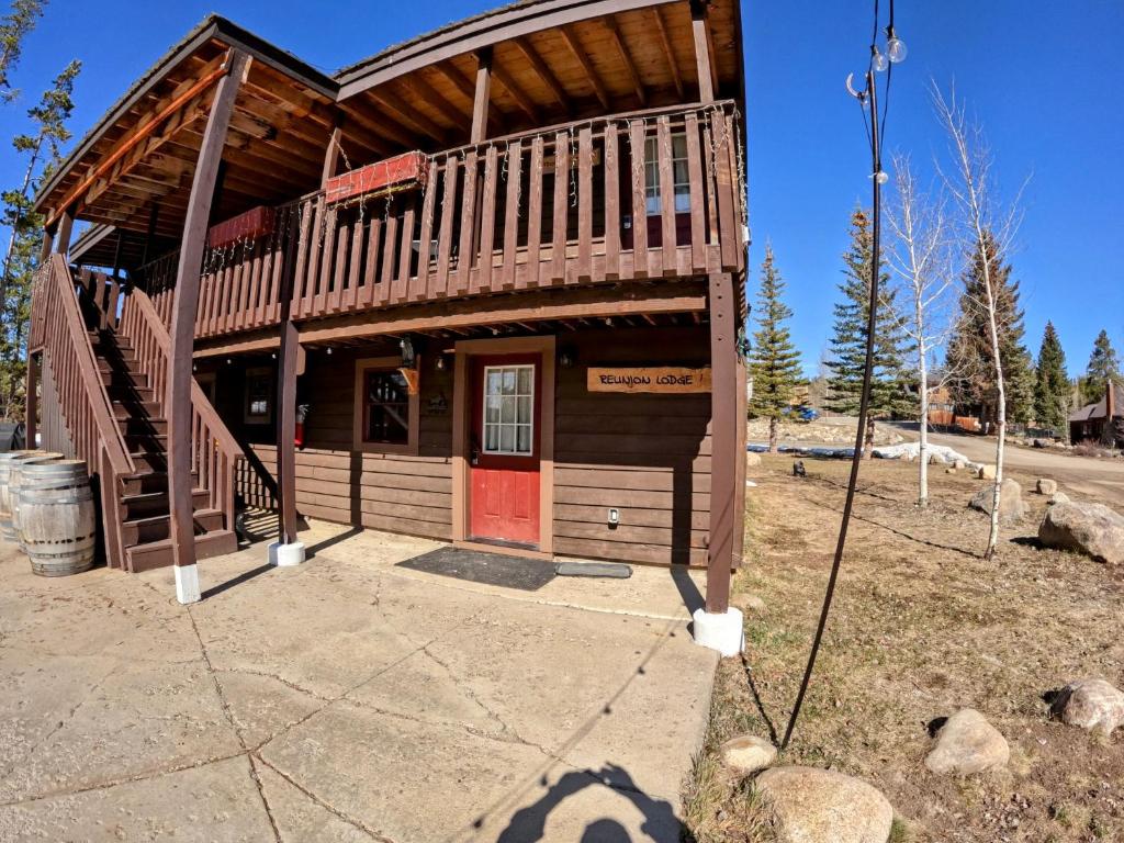 a small wooden cabin with a red door at Reunion Lodge in Grand Lake
