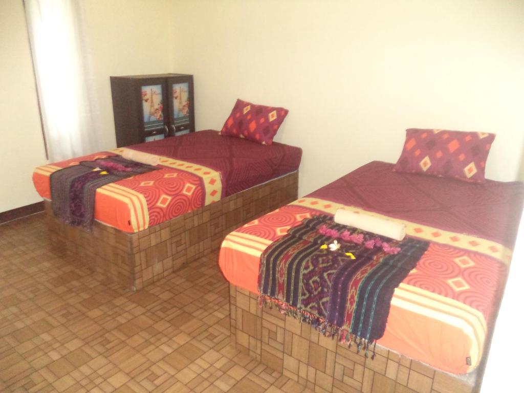 Un pat sau paturi într-o cameră la Kuta Lodge Homestay